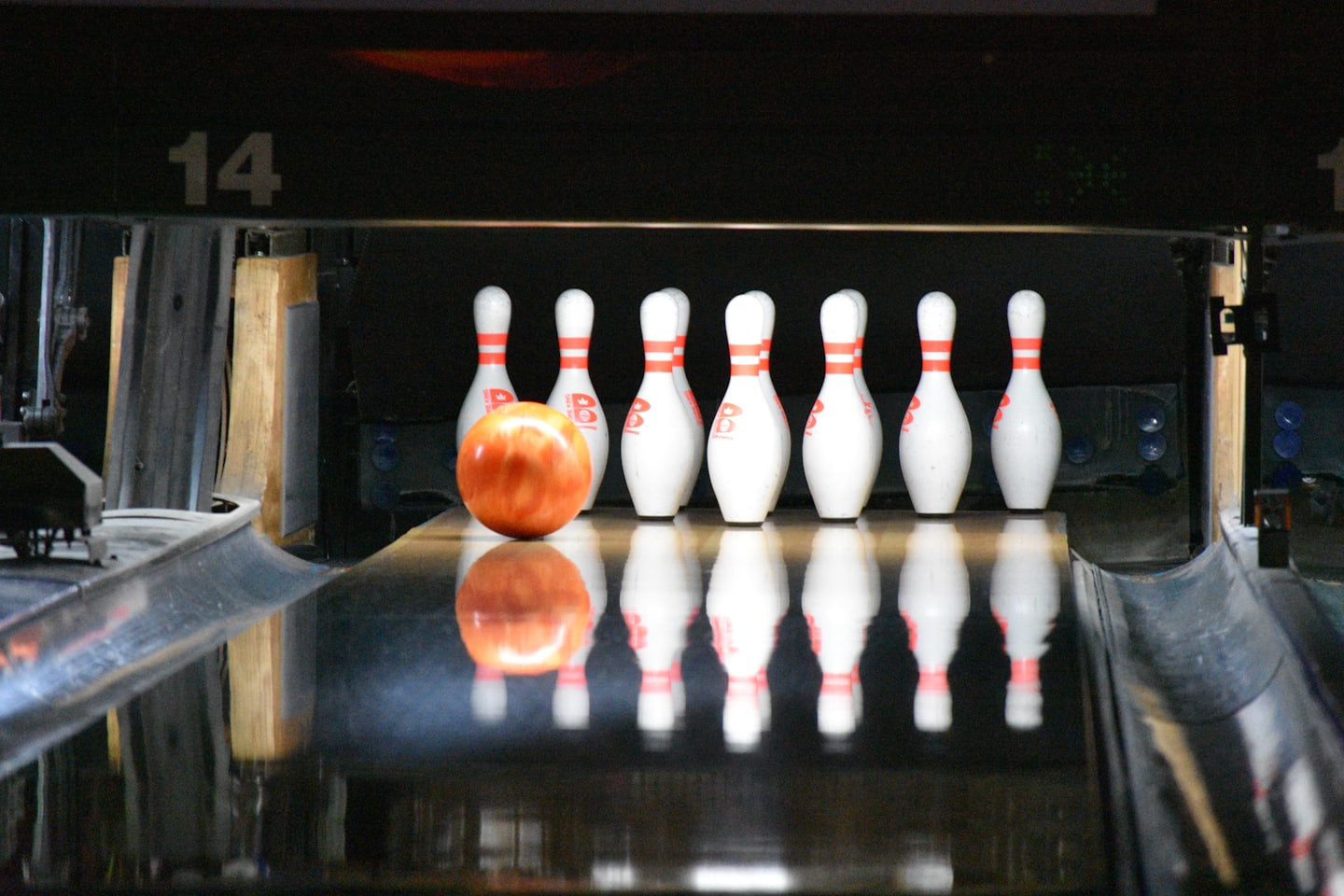 Eine Bowlingkugel vor Pins auf einer Bowlingbahn.